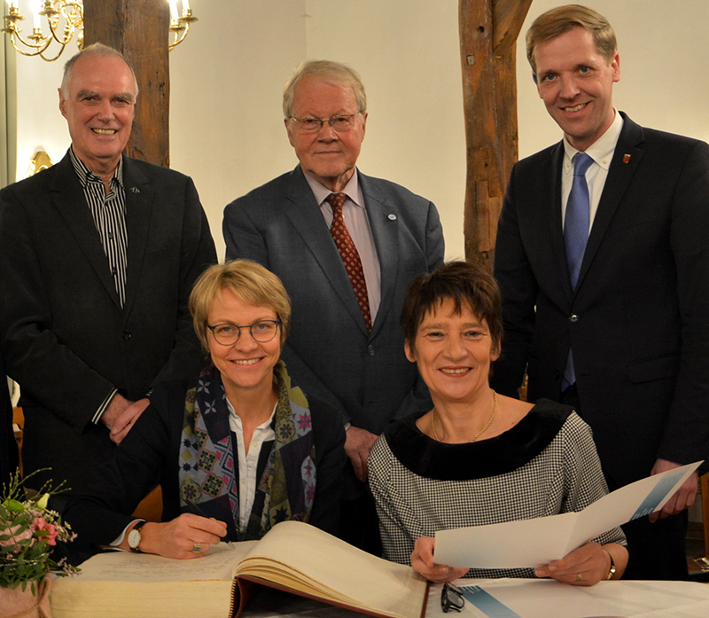 Feierstunde zum offiziellen Beitritt der Gemeinde Nottuln zum Deutschen Riga-Komitee am 14. Januar 2020. Foto: Gemeinde Nottuln Feierstunde zum offiziellen Beitritt der Gemeinde Nottuln zum Riga-Komitee: Regierungspräsidentin Dorothee Feller (sitzend, 1. v.l.) trug sich anschließend noch ins Goldene Buch der Gemeinde Nottuln ein. Unser Bild zeigt neben Dorothee Feller Bürgermeisterin Manuela Mahnke, (v.l.) Robert Hülsbusch (FI Nottuln), Winfried Nachtwei, MdB a.D. und Landrat Dr. Christian Schulze Pellengahr. Foto: Gemeinde Nottuln